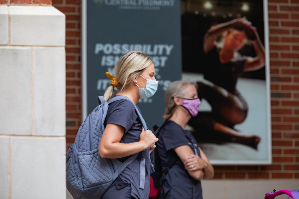 two nursing students walking on campus with face masks