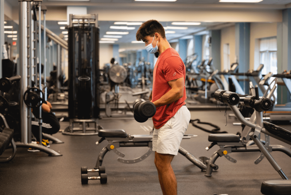 male students lifting dumbbell weights in the Central Campus fitness center