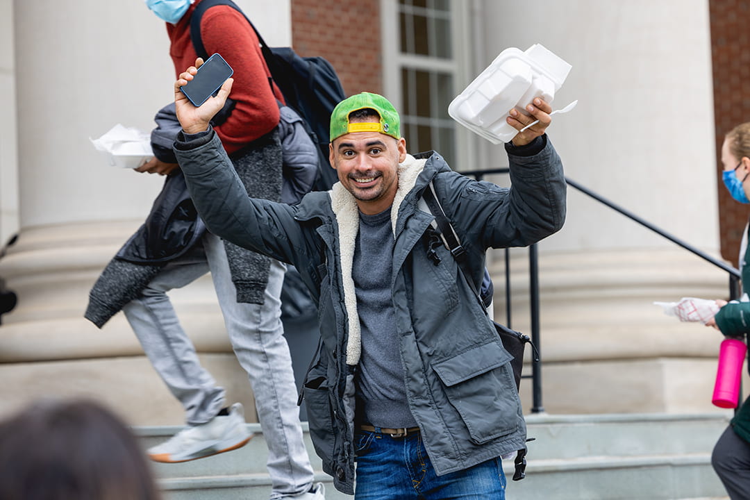male student holding up food container
