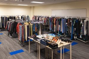 Full room of clothes on racks and wardrobe accessories.