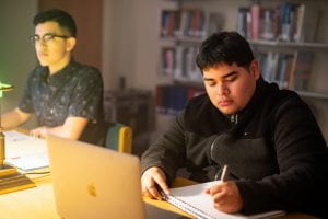 Students work at laptops in a library