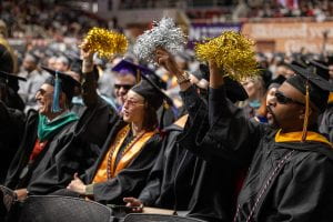 Graduates at commencement, cheering