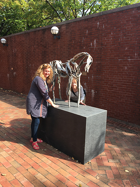 Ceramics instructor Paula Smith and Chair Mary Kilburn pose with Deborah Butterfield's "Lunalilo", a steel sculpture of a small horse at Weatherspoon Art Museum, University of North Carolina-Greensboro.